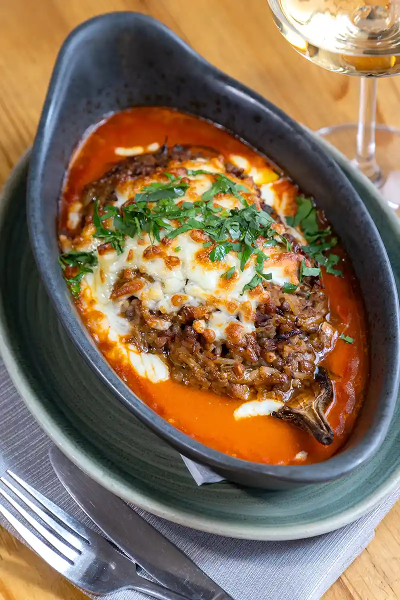 Stuffed Aubergine with green lentil, basmati rice, sun dried cherries, cashew, zaatar and cinnamon, grilled with mozzarella and Bulgarian hard cheese Rodopi, with tomato sauce with saffron - signature main course at Aubergine Sofia